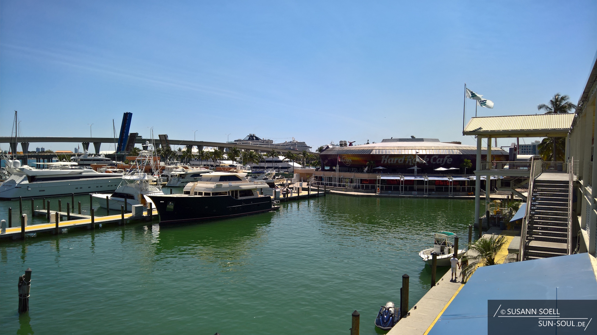 Blick auf das Hard Rock Café am Bayside Marketplace und die davor befindlichen Anleger, an denen verschiedene Boote ankern.