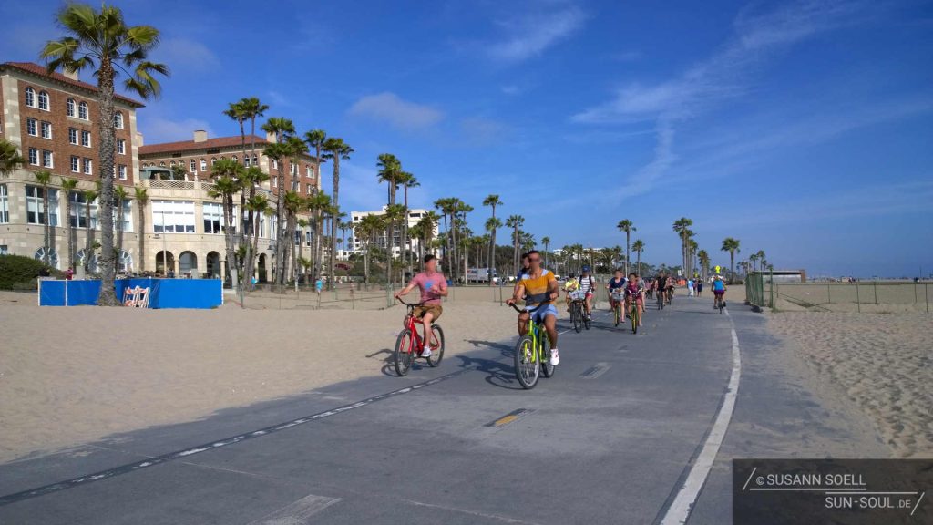 Auf dem Ocean Front Walk and Bike Path vorbeifahrende Fahrradfahrer.