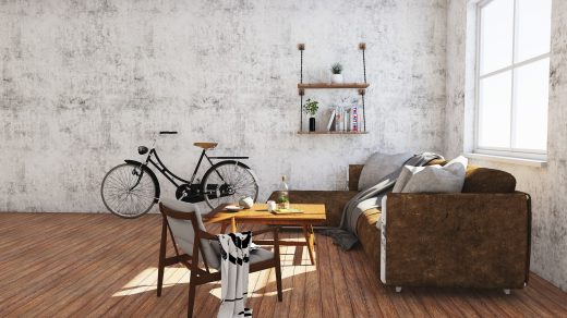 Spartanisch eingerichtete Wohnung mit kahlen Wänden, einem Sofa, einem Tisch, einem Regal und einem Fahrrad, in der ein Student lebt